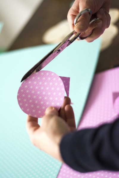 Runde Bastelvorlage wird aus lila Papier mit Muster wird ausgeschnitten
