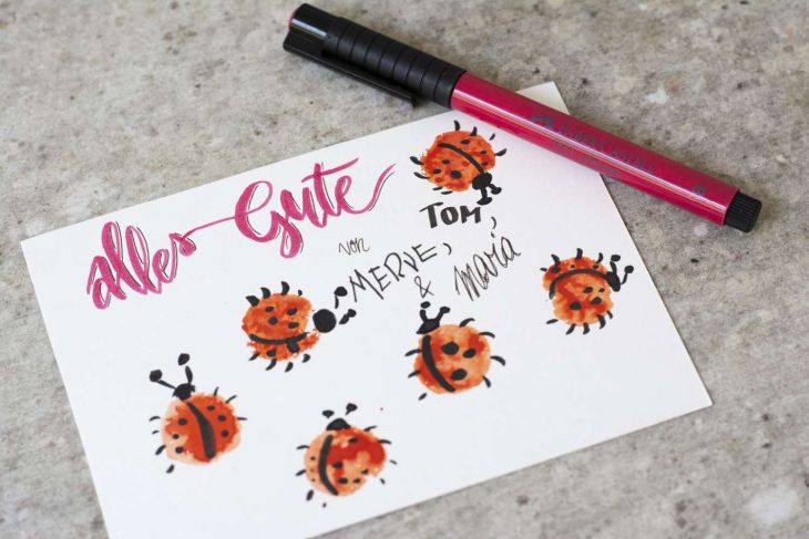 Grußkarte mit gestempelten Marienkäfern und Schriftzug "Alles Gute".