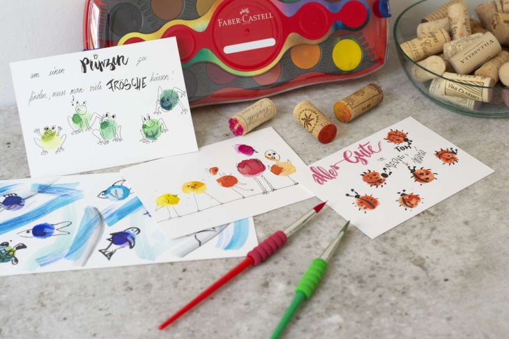 Verschiedene gestempelte Karten mit Wasserfarben und Korken.