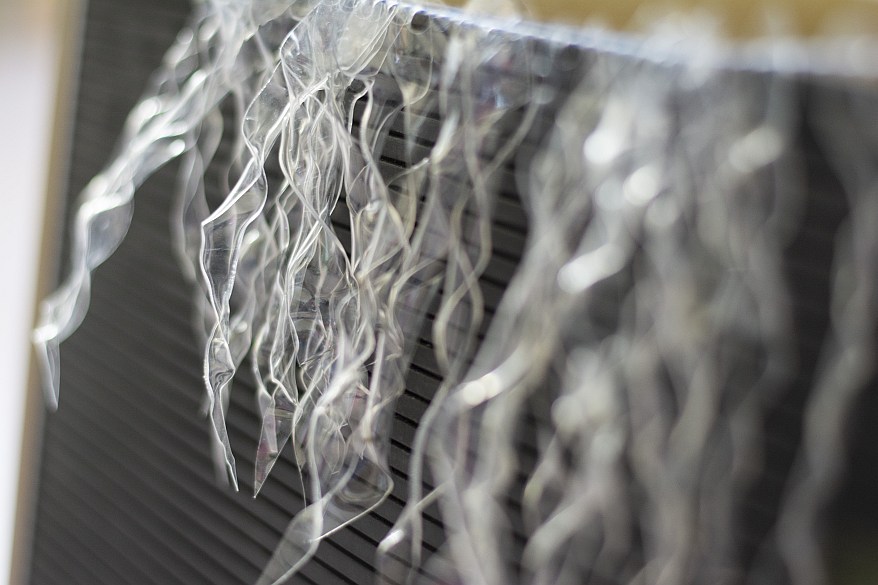 Nahaufnahme von DIY-Eiszapfen aus recycelten Plastikflaschen an einer Tafel.