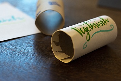 DIY-Papprollen mit Etiketten „Vegetarisch“ und „Fisch“ auf Holztisch.