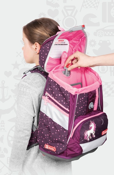 Ein Kind hate einen Step by Step Schulranzen auf dem Rücken. Jemand zeigt im geöffneten Ranzen das verstellbare EASY GROW SYSTEM.