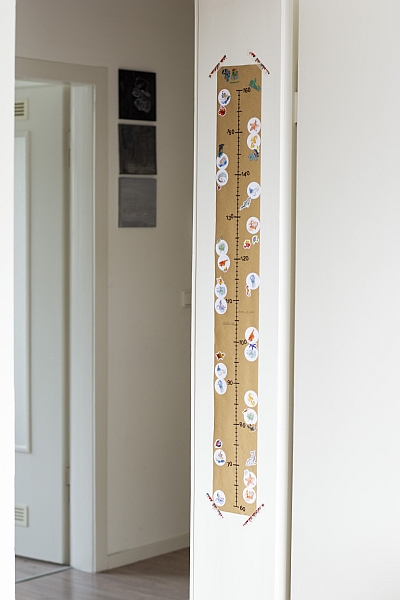 Selbstgebastelte Messlatte hängt an einen Türrahmen.