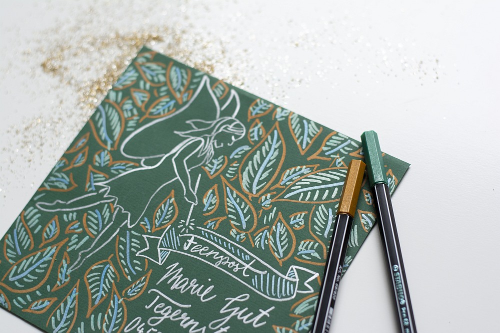 Selbstgestaltete Feenkarte mit Metallic-Stiften und Glitzer auf weißem Untergrund