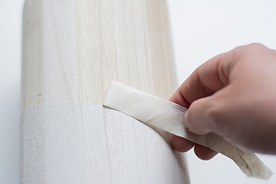 Klebeband wird vorsichtig von bemalter Holzbox abgezogen