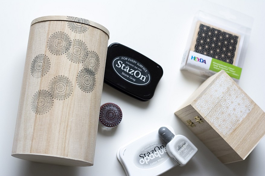 Stempel und Tinte neben bestempelten Holzboxen