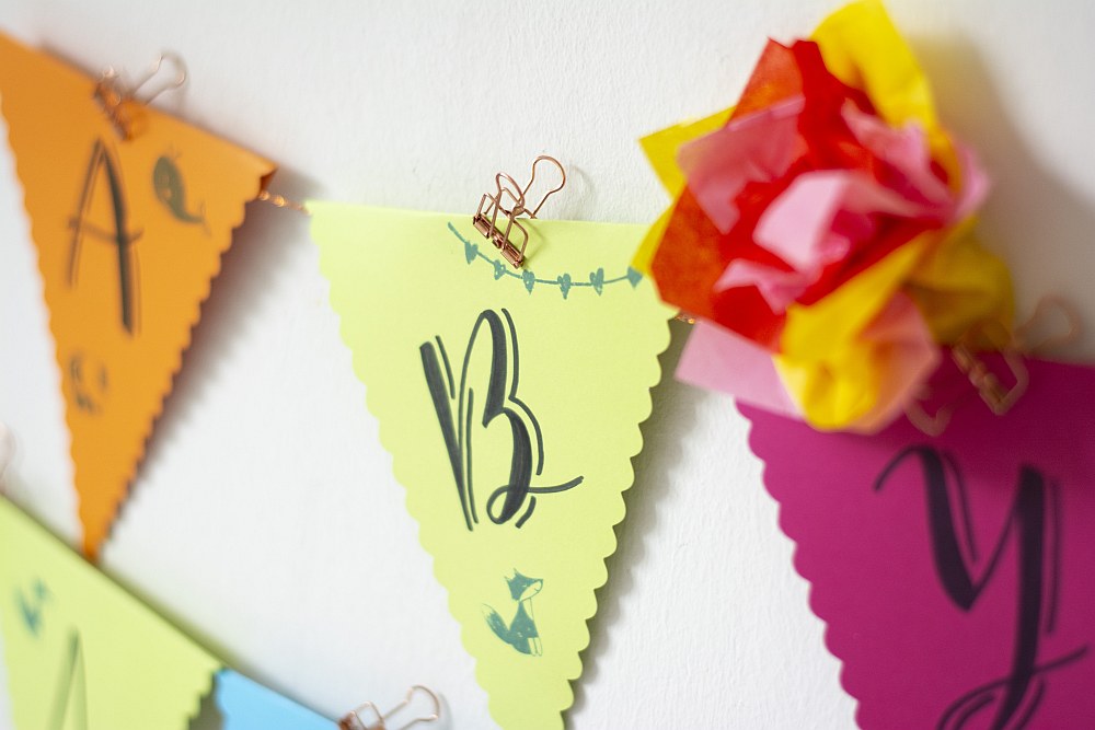 Nahaufnahme eines Wimpels mit dem Buchstaben B und Papierblume