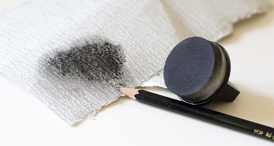 Schwämmchen mit schwarzem, verwischten Graphit auf Papier