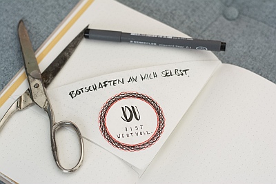 Notizseite mit Schere und Zitat: „Du bist wertvoll“ im Journal
