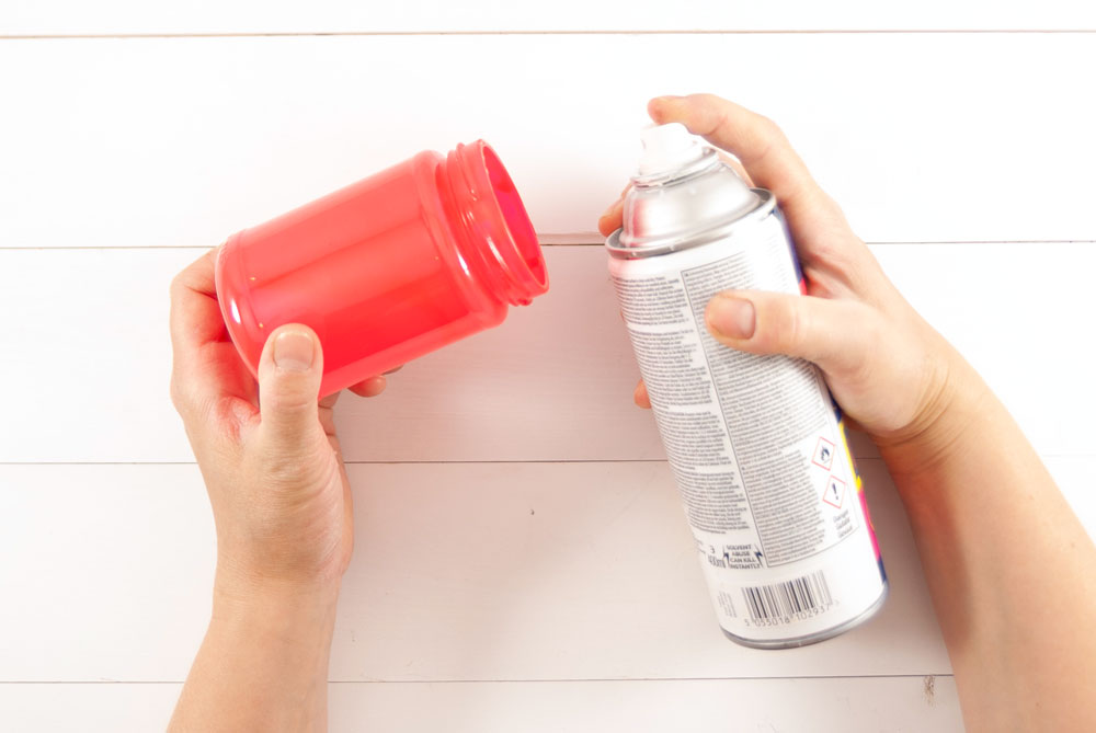 Ein Glas wird mit roter Farbe besprüht