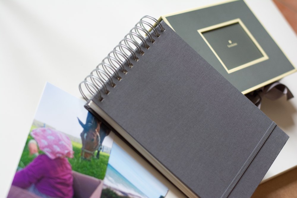 Auf einem Tisch liegt ein schwarzes Ringbuch von Semikolon, daneben steht eine Aufbewahrungsbox von Semikolon.