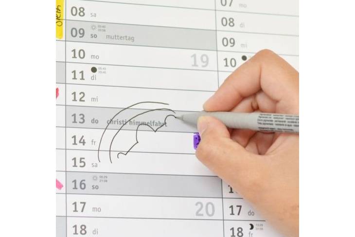 Detailaufnahme eines Kalenders mit dem Feiertag Christi Himmelfahrt, wo jemand gerade etwas draufmalt.