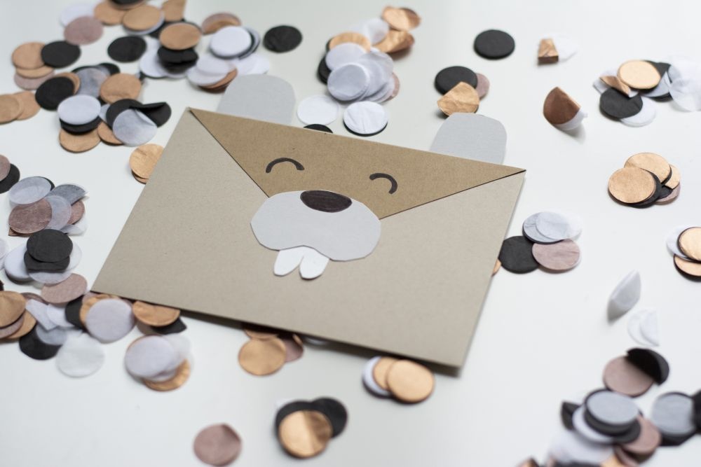 Einladungskarte zum Kindergeburtstag: Selbst gebastelte Do it yourself-Karte als Biber liegt auf Konfetti.