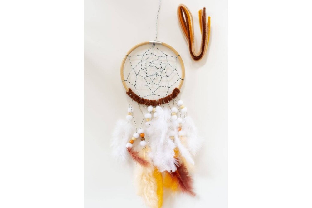 Bastelanleitung Do it yourself-Traumfänger für Kinder basteln. Schritt 4: Den unteren Teil des Holzrings mit Biegeplüsch umwickeln.