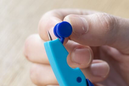 Nahaufnahme einer Hand, die den Spitzenschutz des Schulzirkels griffix von Pelikan einrasten lässt.