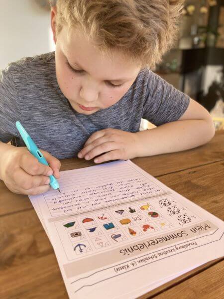 Ein Junge sitzt an einem Schreibtisch und schreibt mit dem Schreiblernfüller Easybirdy von Stabilo eine kreative Schreibübung für die 4. Klasse.