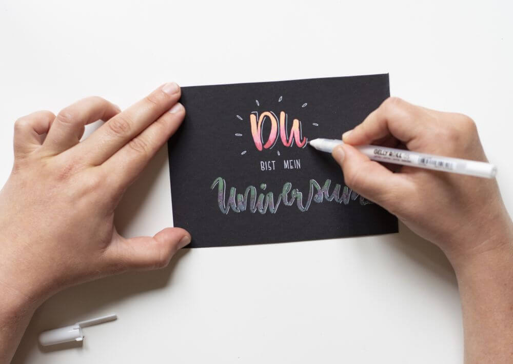 Anleitung Blending mit Gelstiften (Gelly Rolls von Sakura), Schritt 4: Mit einem weißen Gelroller eine Kontur und Akzente um die Worte "Du" und "Universum" setzen.