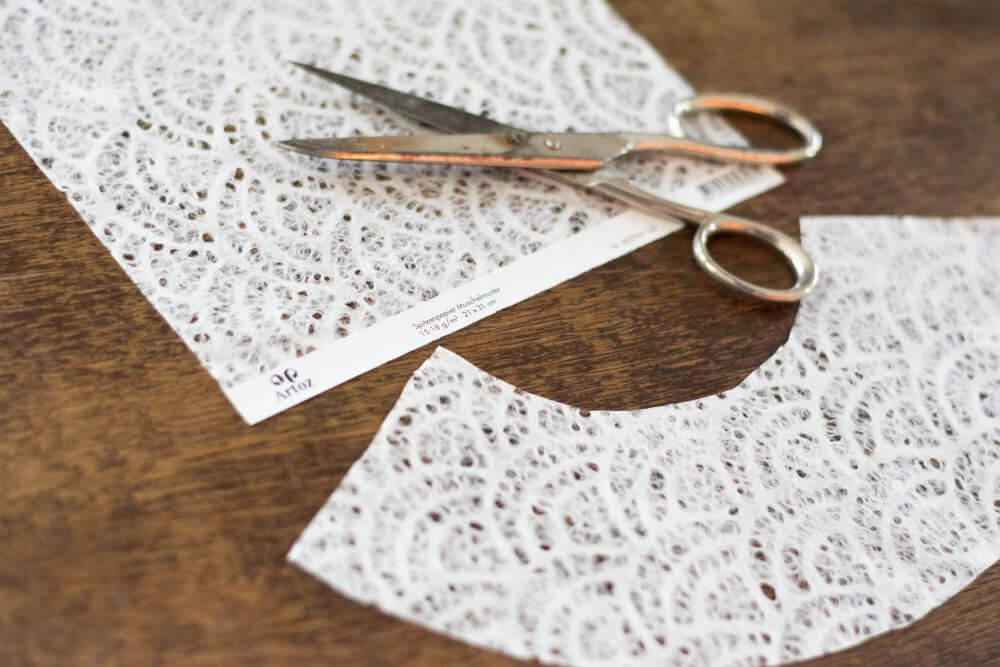 Weißes Spitzenpapier auf einem Holztisch.