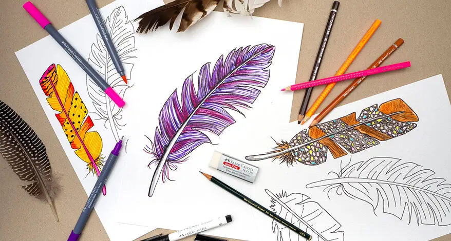 Drei gezeichnete Vogelfeder-Bilder liegen auf einem hellbraunen Untergrund. Drumherum sind Mal- und Zeichenmaterialien von Faber-Castell verteilt. Foto: Johanna Rundel