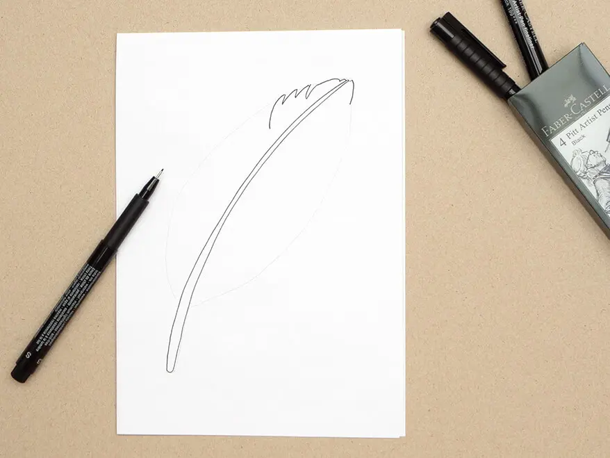 Auf ein Blatt wurde mit einem Pigmentliner von Faber-Castell die Spitze einer Vogelfeder gemalt. Ein Etui mit weiteren Finelinern liegt geöffnet daneben. Foto: Johanna Rundel