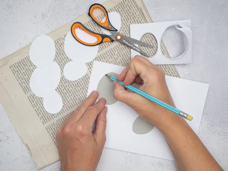 Jemand zeichnet den Umriss eines Papier-Eis aus Fotokarton von Pelikan auf einen Bogen weißes Papier ab. Foto: Johanna Rundel