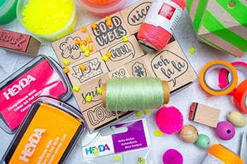 Auf einem hellen Untergrund liegen verschiedene Bastelmaterialien der Marken HEYDA und Knorr PRANDELL.