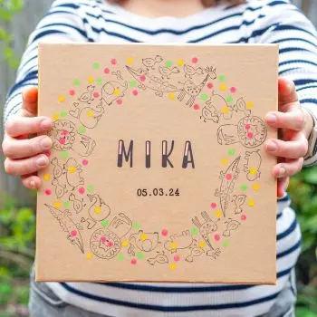 Jemand hält einen mit Stempeln, Aufklebern und Rubbelstickern von HEYDA gestalteten Kartondeckel aus Pappe in die Kamera. Foto: Johanna Rundel