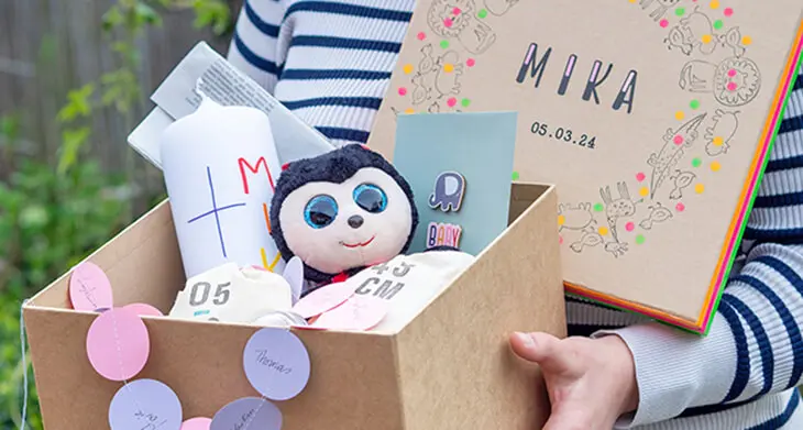 Jemand hält eine aus einer Pappkiste von KNORR prandell selbstgebaute Zeitkapsel geöffnet in die Kamera. Foto: Johanna Rundel