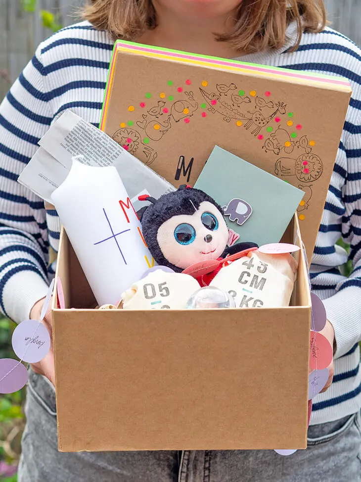 Jemand hält eine, aus einer Pappkiste von KNORR prandell selbstgebaute, Zeitkapsel geöffnet in die Kamera. Foto: Johanna Rundel