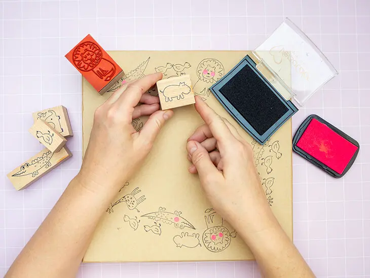 Jemand stempelt mit Stempeln von HEYDA Tiermotive auf den Deckel einer Pappschachtel von KNORR prandell. Foto: Johanna Rundel