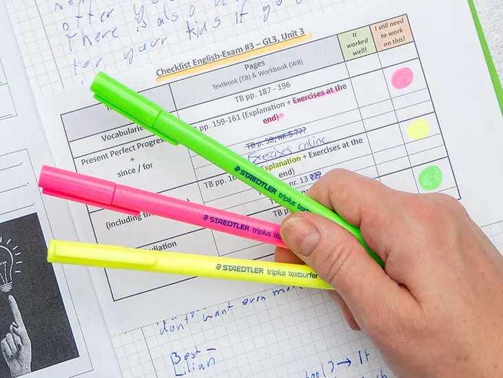 Jemand hält drei verschiedenfarbige Textmarker von STAEDTLER über eine im Ampelsystem markierte Checkliste zur Vorbereitung auf Klassenarbeiten. Foto: Johanna Rundel
