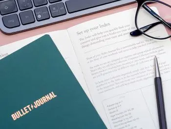 Auf einer rosa Schreibtischunterlage liegt ein aufgeschlagenes Anleitungs-Booklet für das Bullet Journal von LEUCHTTURM1917. Foto: Johanna Rundel