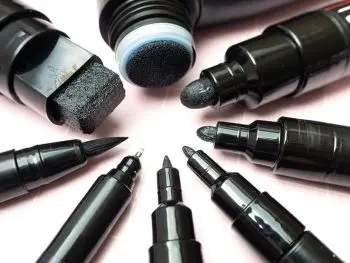 Acht POSCA-Marker mit unterschiedlichen Stiftspitzen liegen auf einem rosa Untergrund. Foto: Johanna Rundel