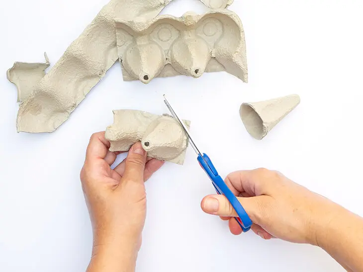 Jemand schneidet mit einer Schere Blütenblätter aus den Seitenwänden eines Eierkartons. Foto: Johanna Rundel