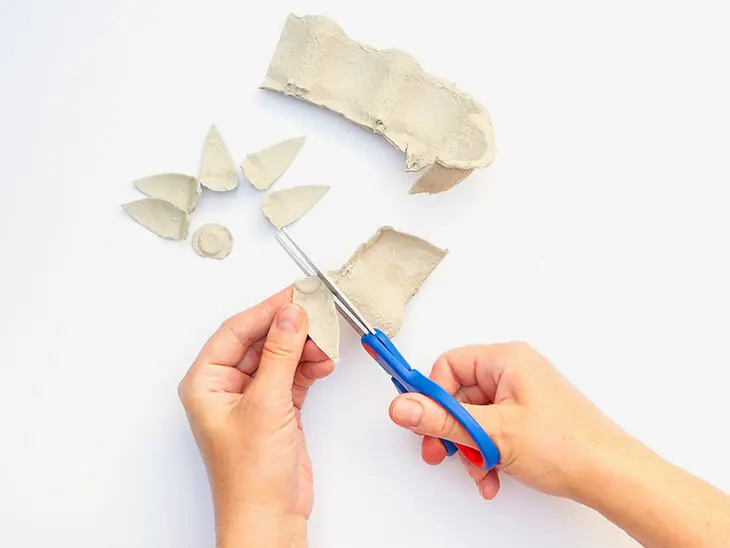 Jemand schneidet mit einer Schere Blütenblätter aus den Seitenwänden eines Eierkartons. Foto: Johanna Rundel