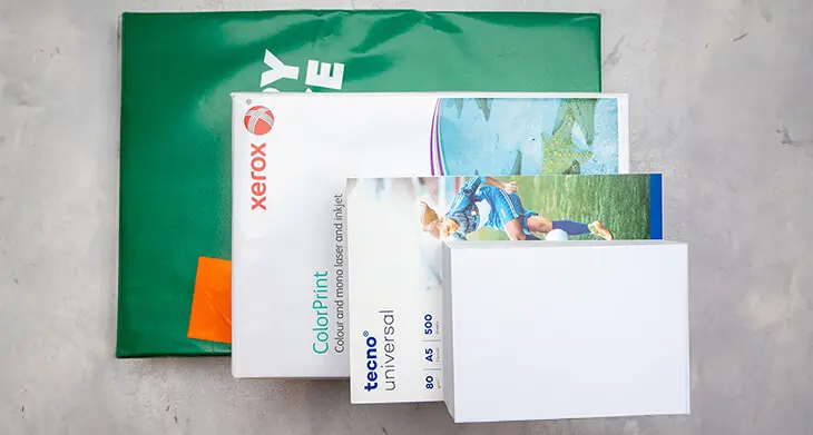Kopierpapier-Packungen in unterschiedlichen Formaten liegen der Größe nach – von DIN A3 bis DIN A6 – aufeinander gestapelt auf einem hellgrauen Untergrund. Foto: Johanna Rundel