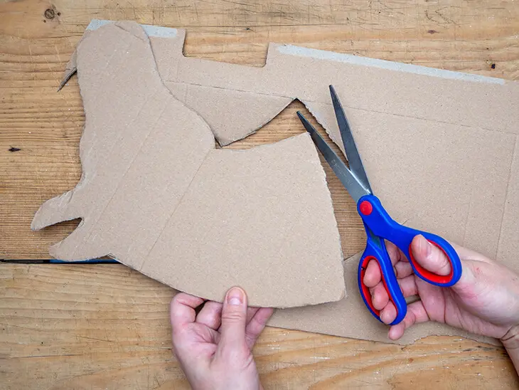 Jemand schneidet mit einer Schere von STAEDTLER den Umriss eines Pferdekopfes aus Karton aus. Foto: Johanna Rundel