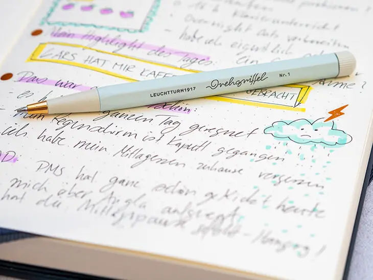 Ein türkisfarbiger Drehgriffel von LEUCHTTURM1917 liegt auf einem aufgeschlagenen daily log in einem Bullet Journal. Foto: Johanna Rundel