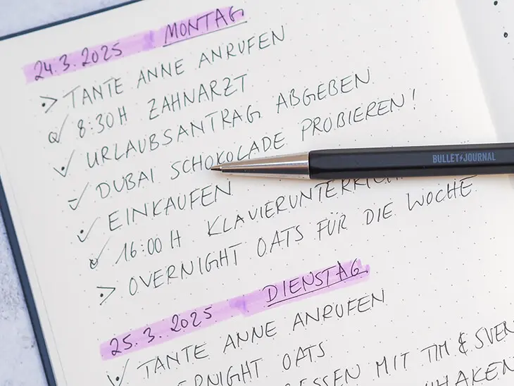 In einem Bullet Journal von LEUCHTTURM1917 ist ein minimalistisch gehaltener daily log zu sehen. Darauf liegt ein dunkler Drehgriffel. Foto: Johanna Rundel