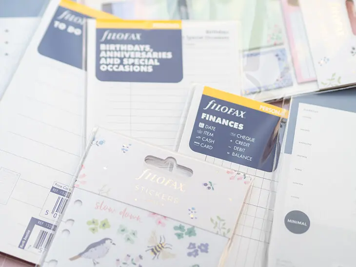 Viele verschiedene Einlagen, Sticker und Haftnotizen von Filofax liegen auf einem rosa Untergrund verteilt. Foto: Johanna Rundel