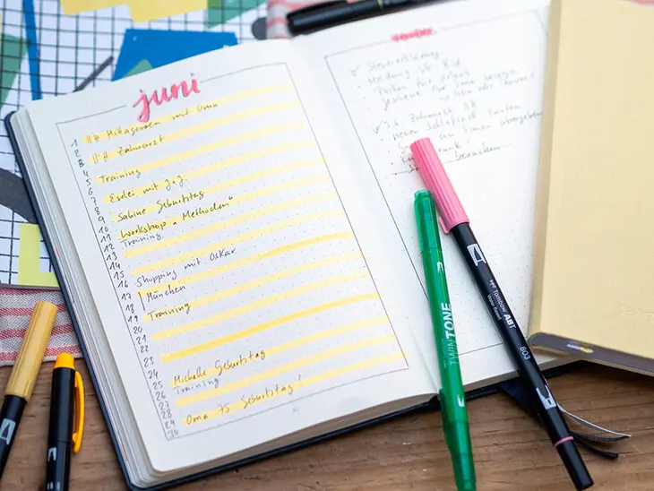 Ein aufgeschlagenes Bullet Journal, auf der Doppelseite ist ein monthly log in Listen-Ansicht angelegt. Verschiedene Stifte von Tombow liegen zur Gestaltung bereit. Foto: Johanna Rundel
