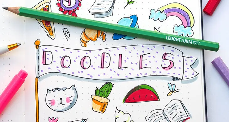 Eine Seite eines Bullet Journals von LEUCHTTURM1917 ist voll mit ganz verschiedenen bunten Doodles. Darauf liegt ein grüner Bleistift. Foto: Johanna Rundel