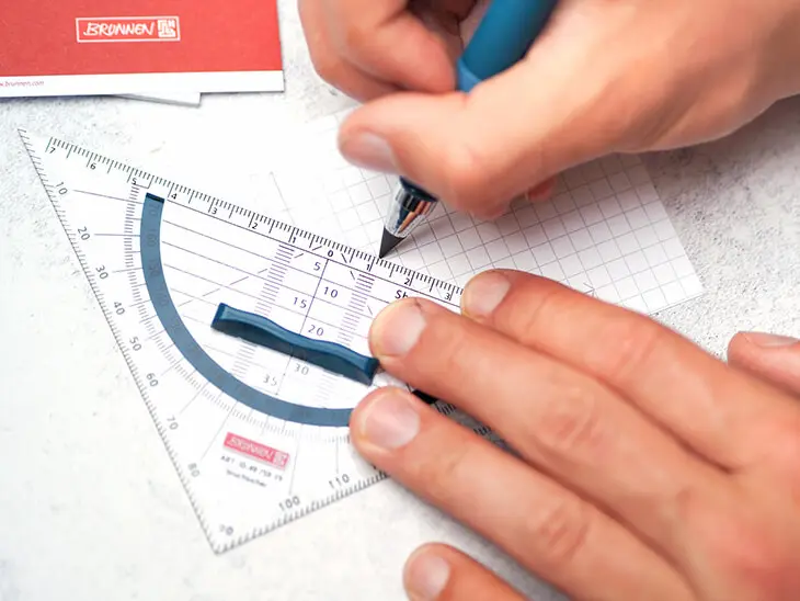 Jemand zeichnet mit einem Geodreieck von BRUNNEN auf eine Karteikarte. Foto: Johanna Rundel