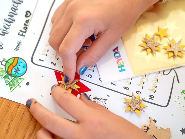 Ein Kind klebt einen Stern-Aufkleber von HEYDA auf seinen Wunschzettel. Foto: Johanna Rundel