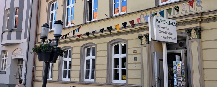 Eingang Papierhaus Hartmann in Greifswald mit Wimpelkette