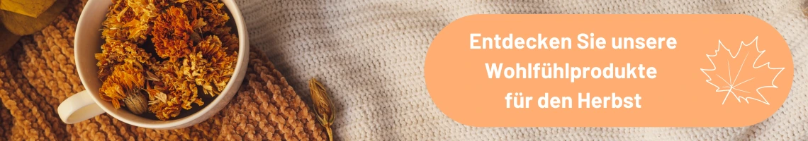 Auf einer Decke steht eine Tasse mit Blättern drin.