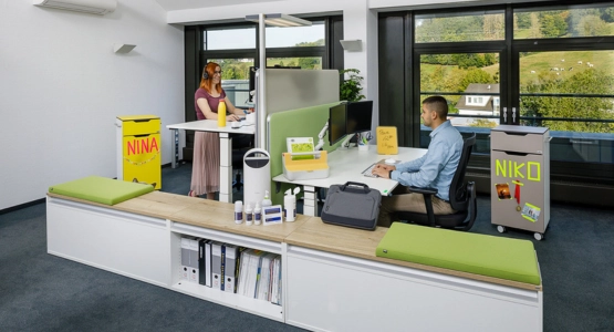 Zwei Personen sitzen an Ihren ergonomischen Schreibtischen.