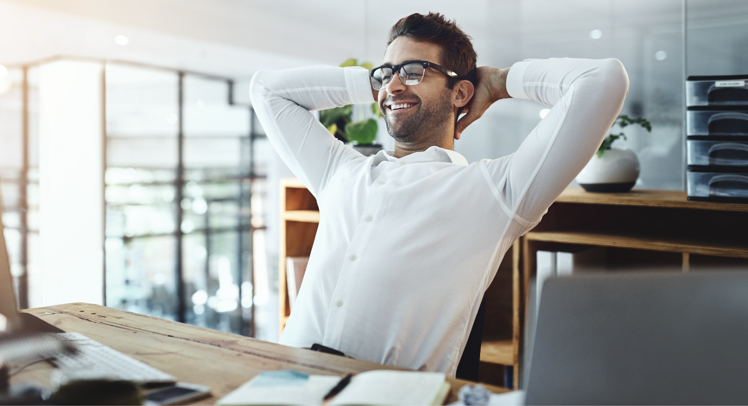 Ein Mann lehnt sich entspannt im Büro zurück.