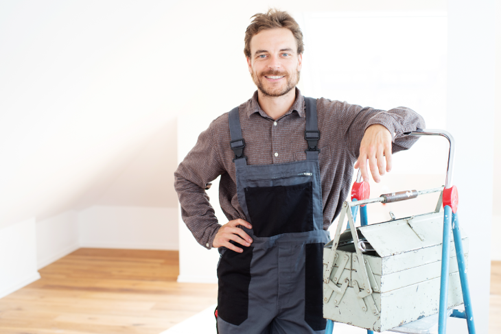 Ein Handwerker lehnt an einer Leiter.