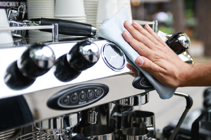 Eine Person wischt über eine Kaffeemaschine